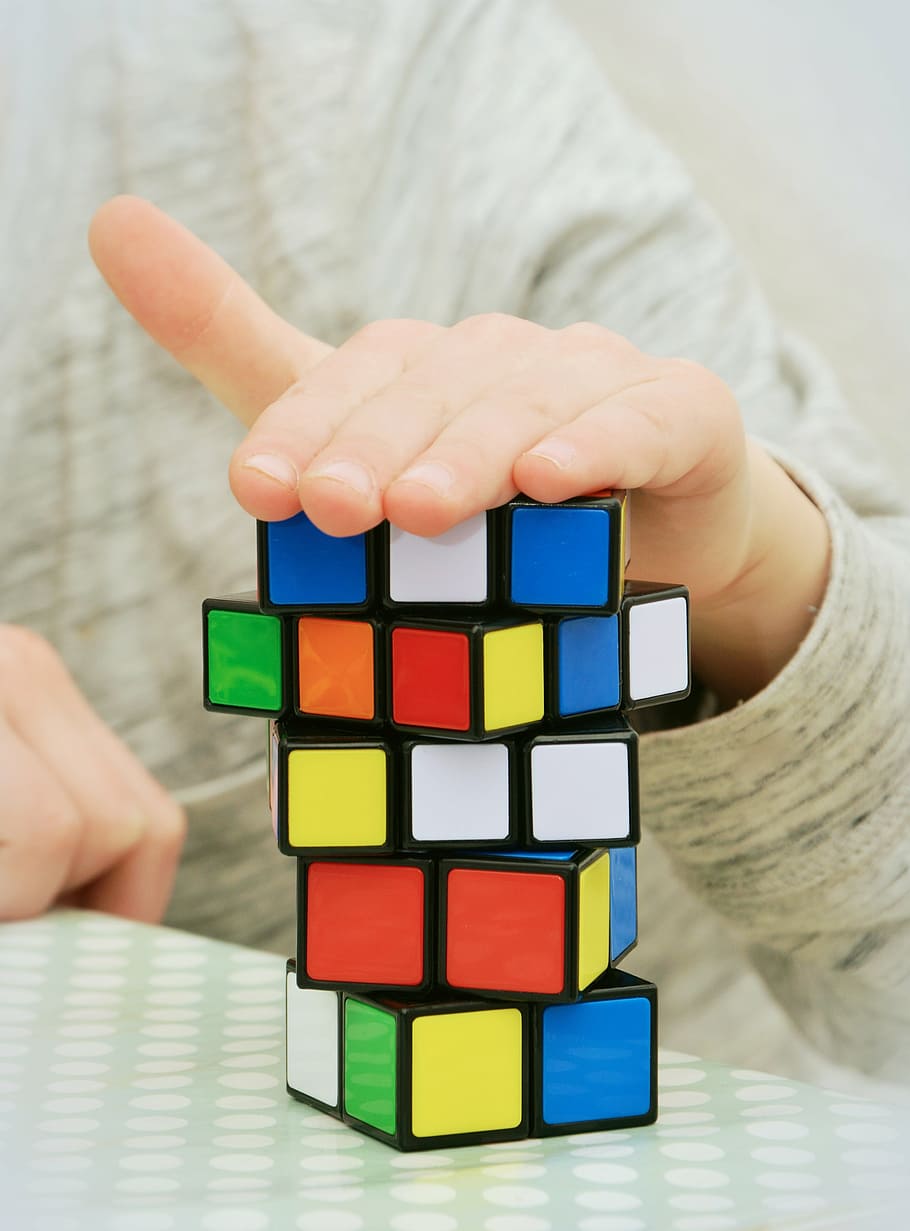 person with hand on top of Rubik's Cube, magic cube, patience HD wallpaper