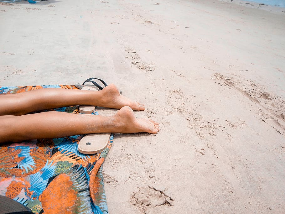 bare foot person lying on orange textile on brown sand during daytime, person laying on sand ground HD wallpaper