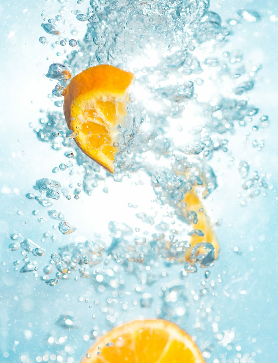 sliced orange fruits underwater, citrus in water, bubbles, drink