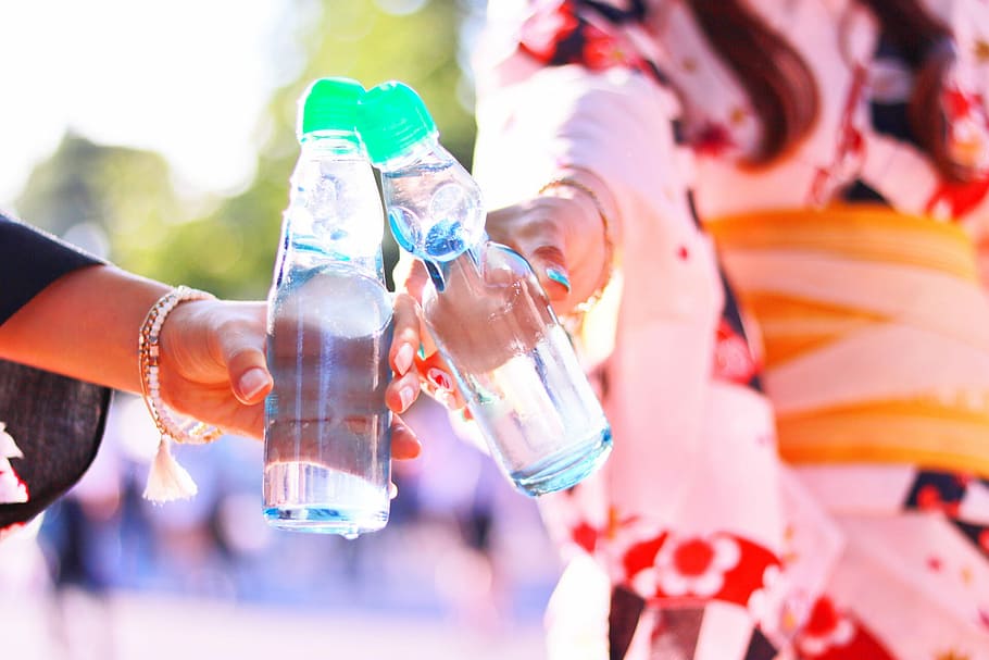 two people holding clear plastic bottles, outdoors, lifestyles HD wallpaper
