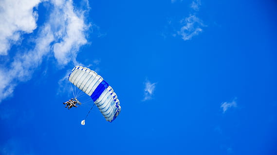 low-angle photography of person riding fan-powered chair with parachute up in sky, man paragliding from sky HD wallpaper