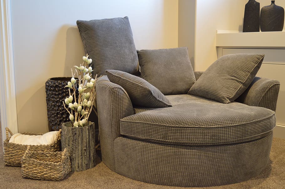 grey fabric chair near white wall paint, sofa, furniture, comfortable