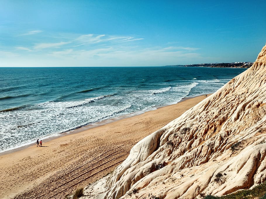 brown sand sea shore, people walking towards ocean during daytime HD wallpaper