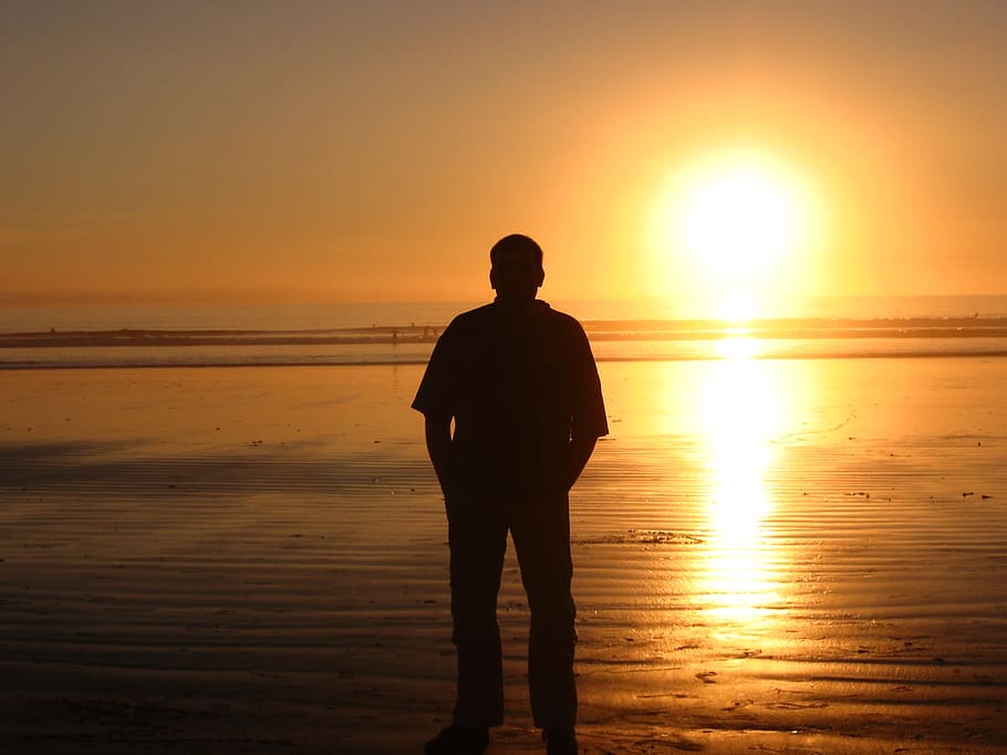 man, sea, sun, sunset, sky, water, beach, orange color, standing HD wallpaper