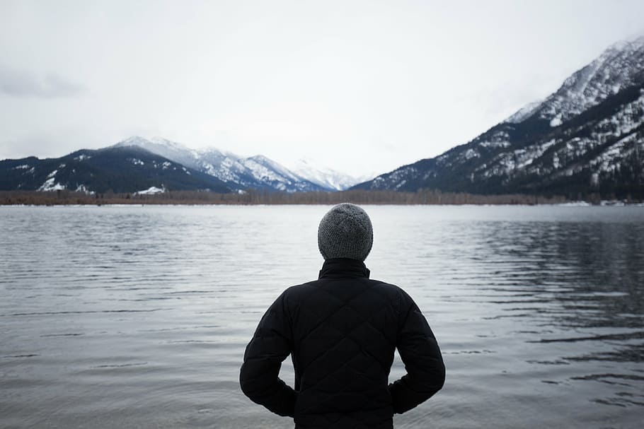 person wearing black jacket standing near body of water, gray, HD wallpaper