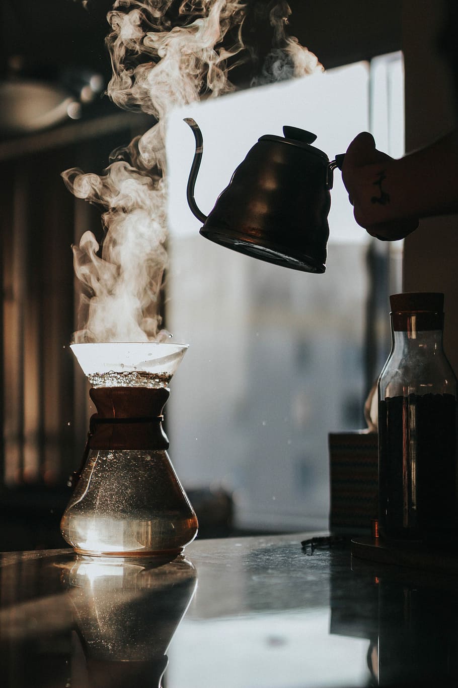 person holding teapot with boiled water, person holding kettle above clear glass container HD wallpaper