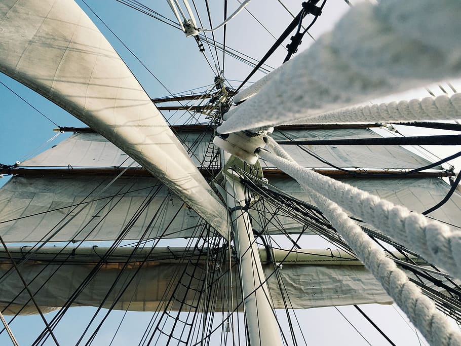 white and gray galleon ship part during daytime, low angle photo of brown boat sail