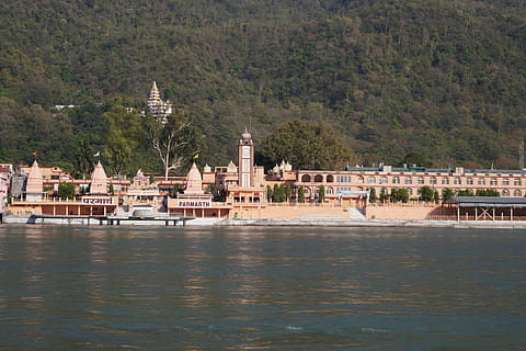 brown concrete buildings near body of water and hill at daytime HD wallpaper