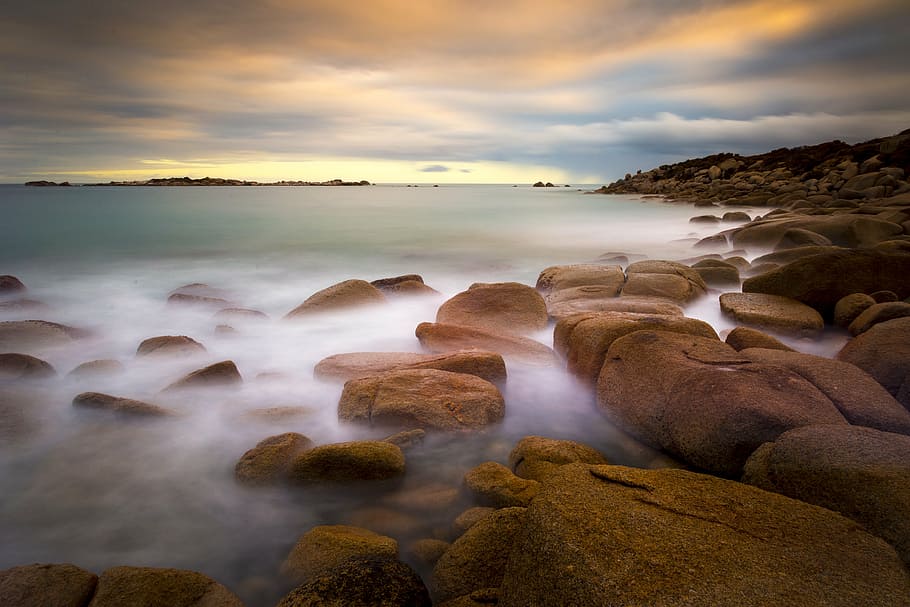rocks beside body of water, beach, sand, cloud - sky, sunset HD wallpaper