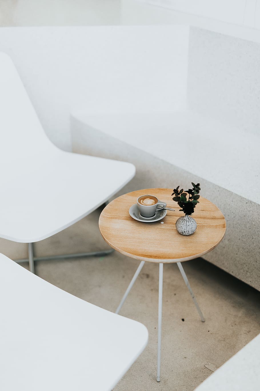round brown table beside two white chairs, gray ceramic teacup on platter beside green leafed plant on round side table HD wallpaper