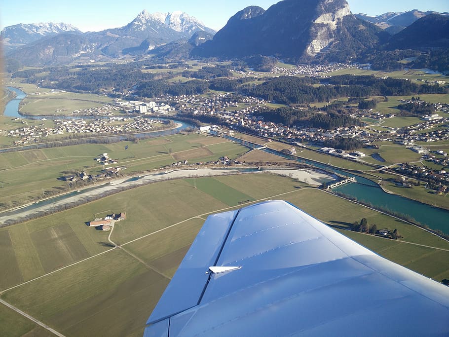 person taking photo of landmark inside plane during daytime, river