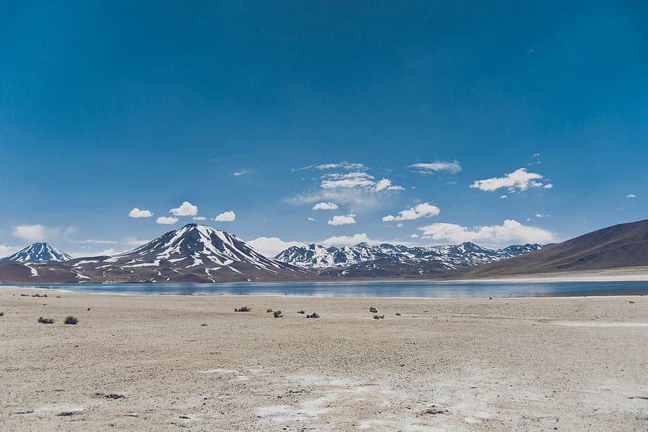Lake Uyuni, Bolivia, person taking photo of blue body of water near snow covered mountains at daytime HD wallpaper
