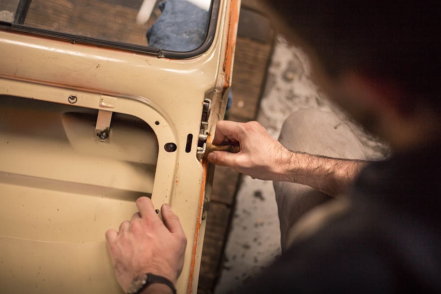 A man adjusting the lock mechanism on a car door, person holding car frame HD wallpaper
