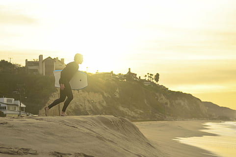 person holding bodyboard running towards the sea, people, man HD wallpaper