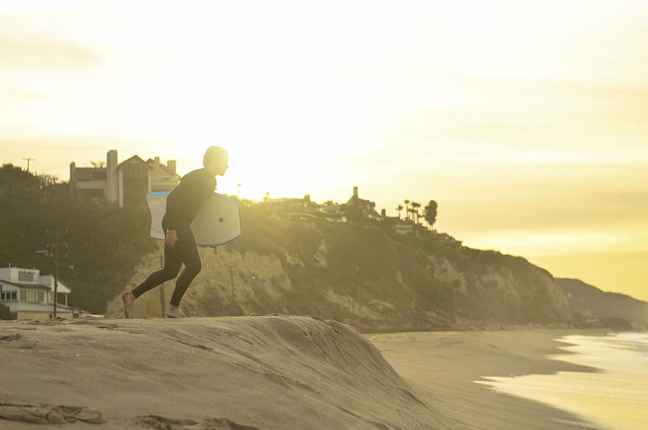person holding bodyboard running towards the sea, people, man HD wallpaper