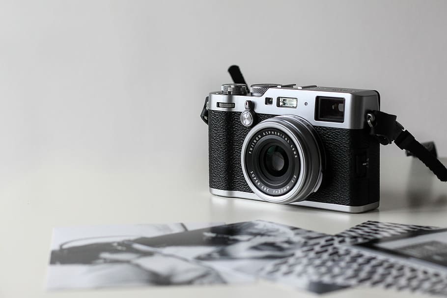 black and gray film camera near printed photos, black and gray DSLR camera on white surface HD wallpaper