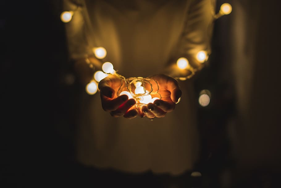 person holding string lights, person holding white string lights