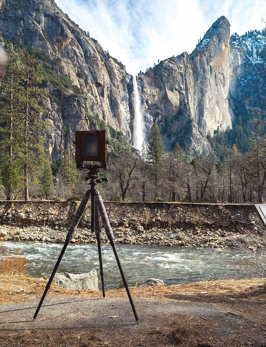 brown camera with tripod near on body of water, brown lamp on tripod near waterfalls HD wallpaper