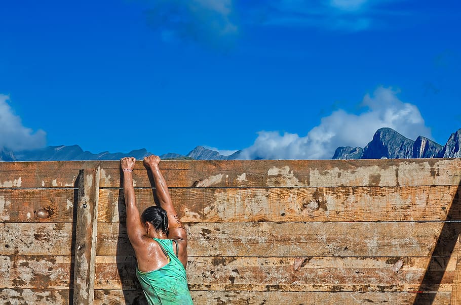 person wearing green tank top climbing on brown wooden surface HD wallpaper