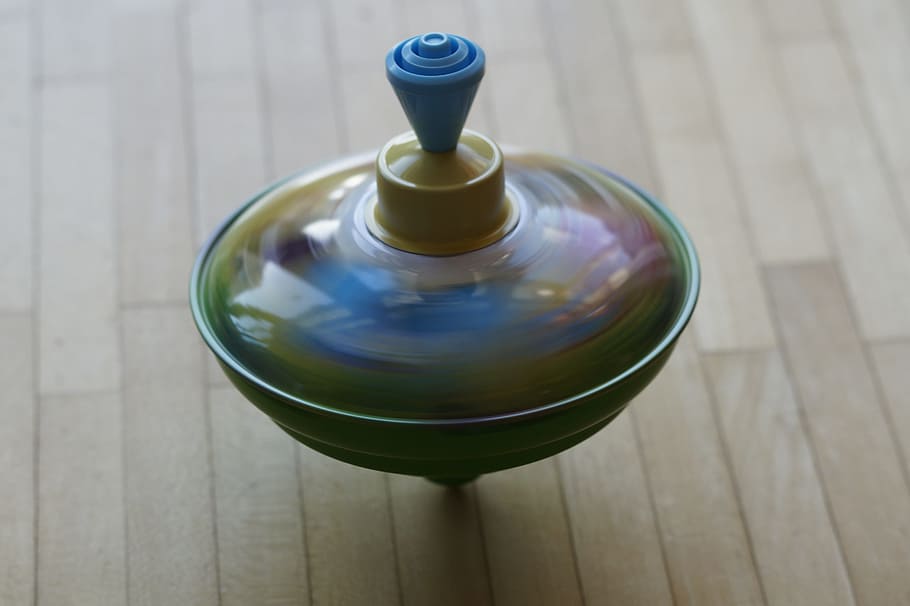 blue and green spin top spinning on brown surface, roundabout HD wallpaper