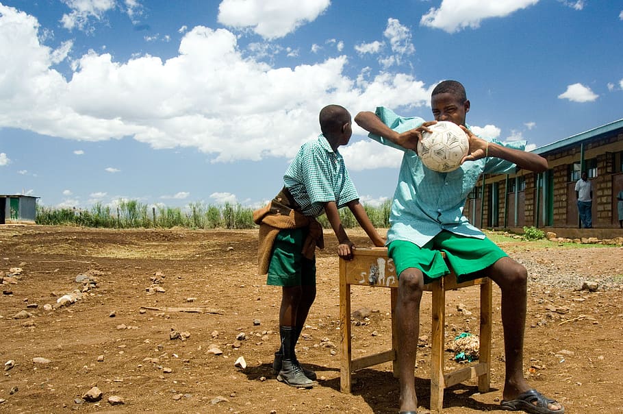 boy wearing blue shirt holding white ball while sitting, kenya HD wallpaper