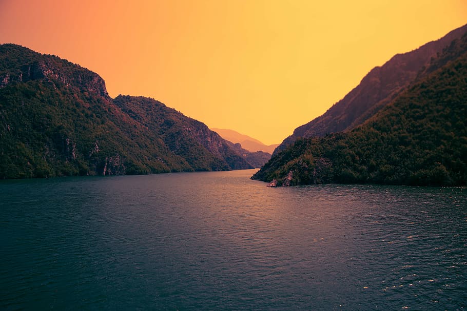 river surrounded by mountain photo during dawn, green mountain hill beside blue sea HD wallpaper
