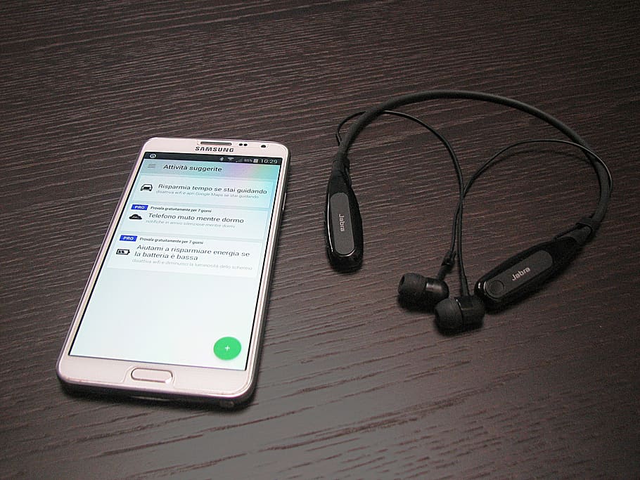 white Samsung Android smartphone beside stereo neckband headphones HD wallpaper