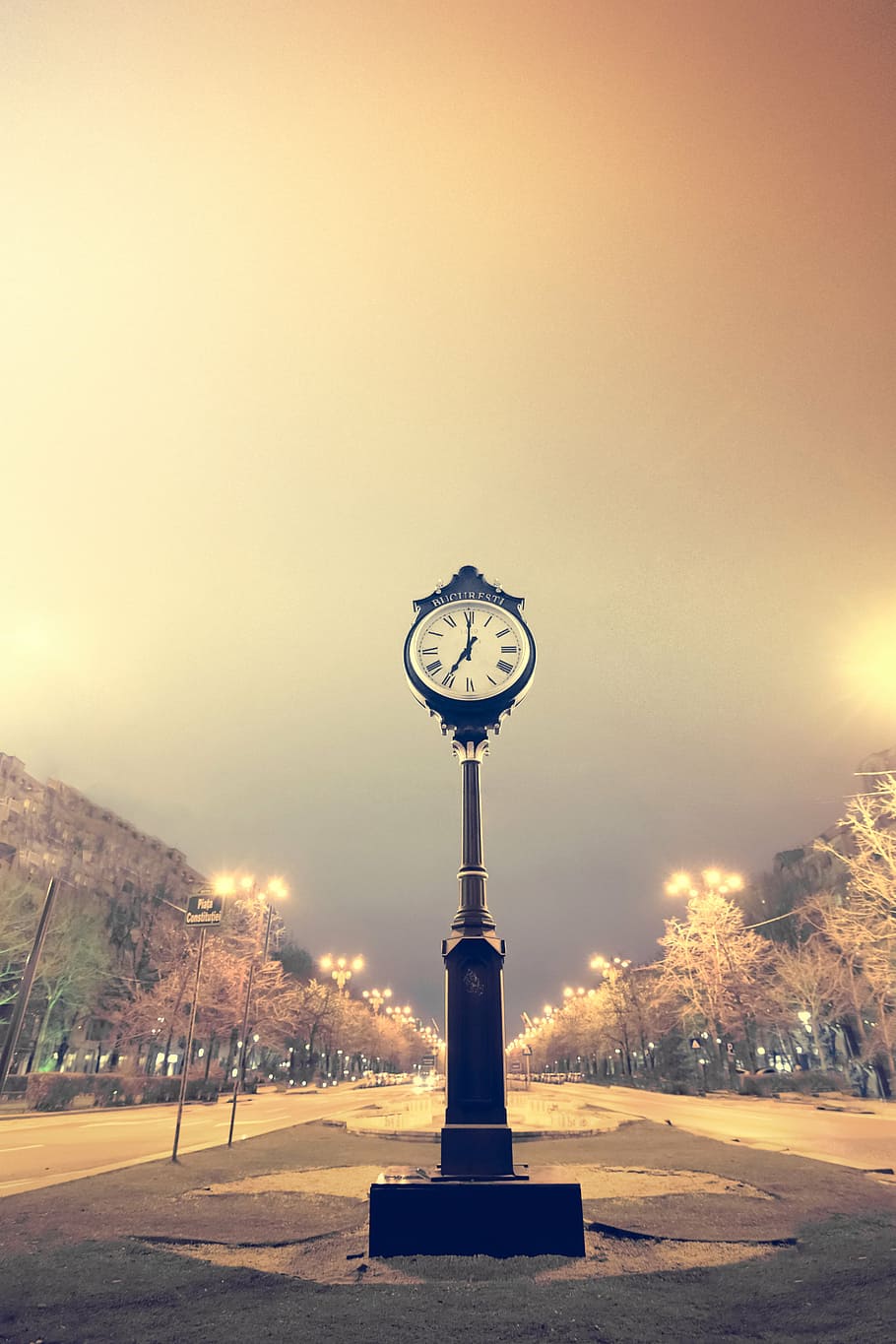 photo of pedestal clock on road at nighttime, bucharest, time clock