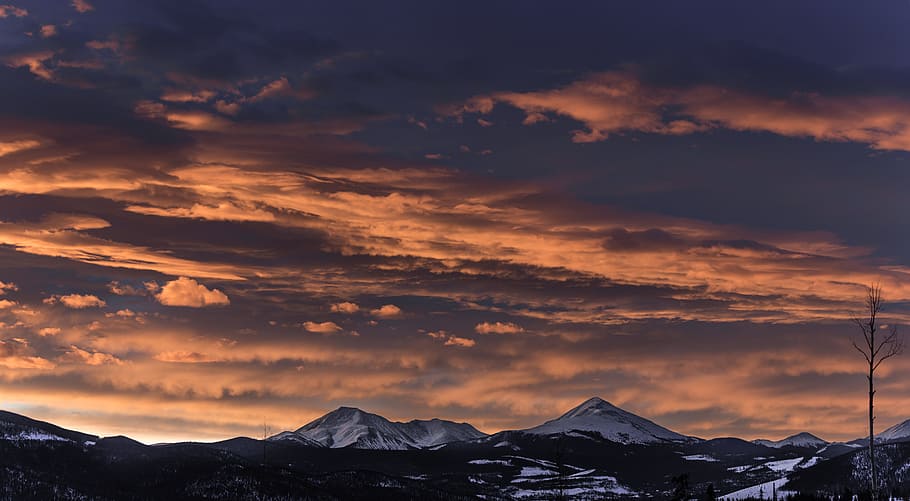 mountain under cloudy sky during day time, snow covered mountains during sunset