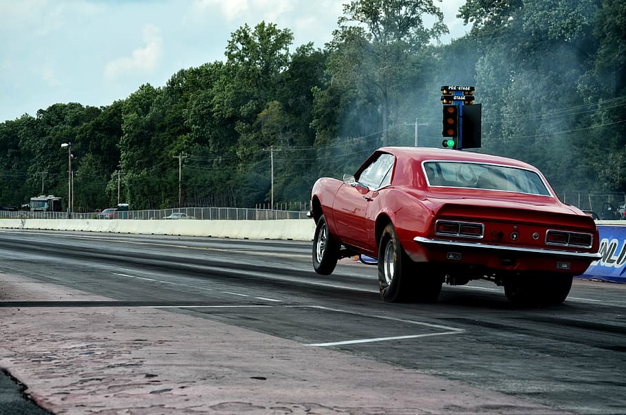 red muscle car on drag strip during daytime, power, speed, transportation