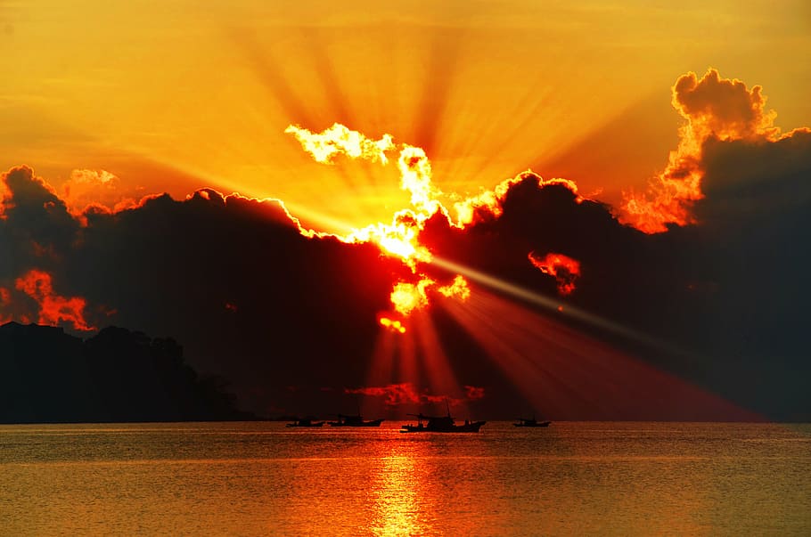 silhouette photography of calm water under crepuscular ray HD wallpaper