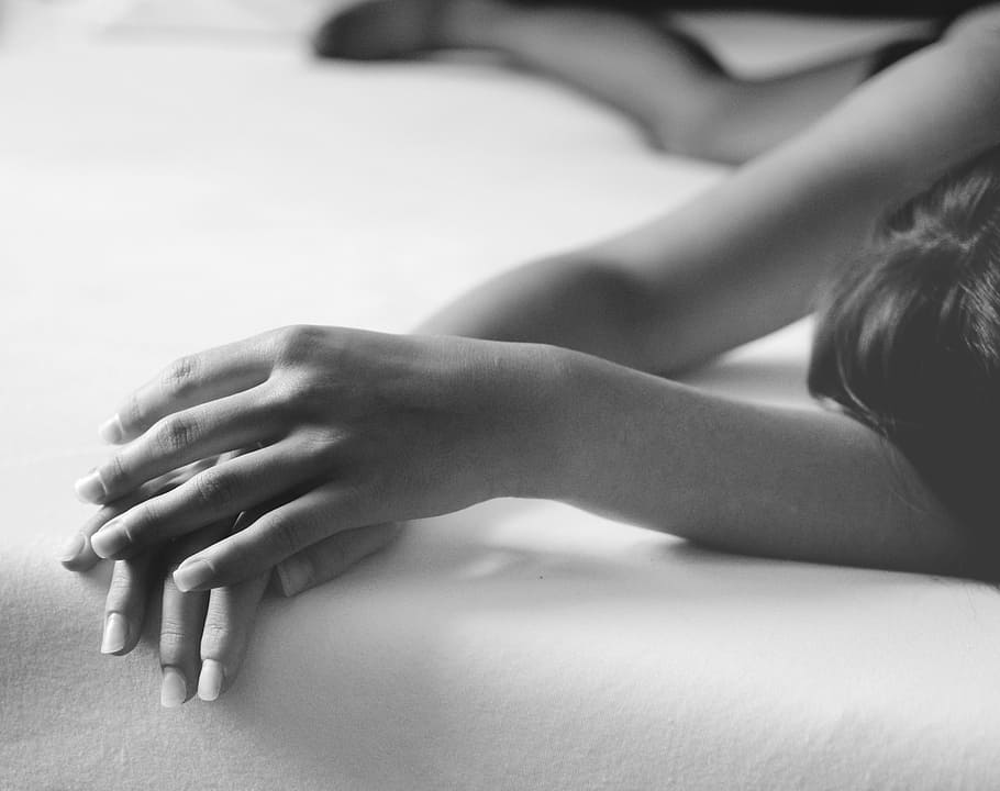 grayscale photography of woman lying on white bed linen, black And White HD wallpaper