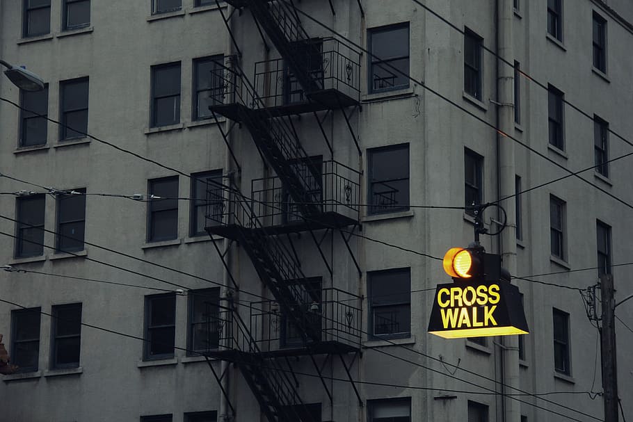 lighted Cross Walk street signage near concrete building, gray concrete high-rise building HD wallpaper