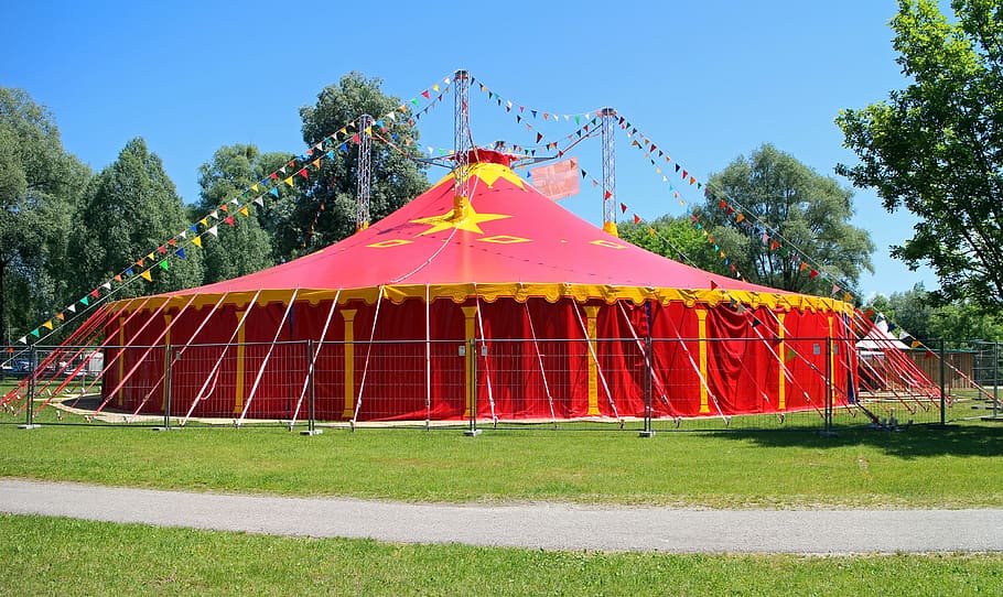yellow and red canopy tent under blue sky, circus, circus tent