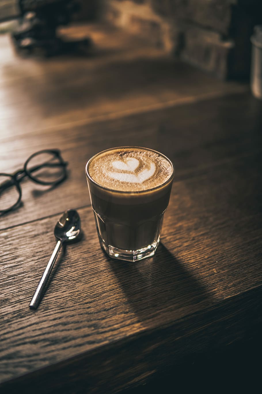 cappuccino with heart latte art on brown wooden table surface, latte coffee on clear drinking glass, HD wallpaper