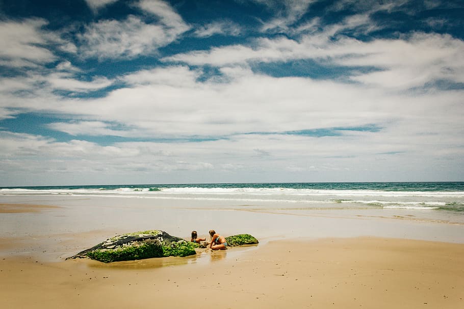 photo of two women on shore under cloudy sky, two persons on the shore HD wallpaper