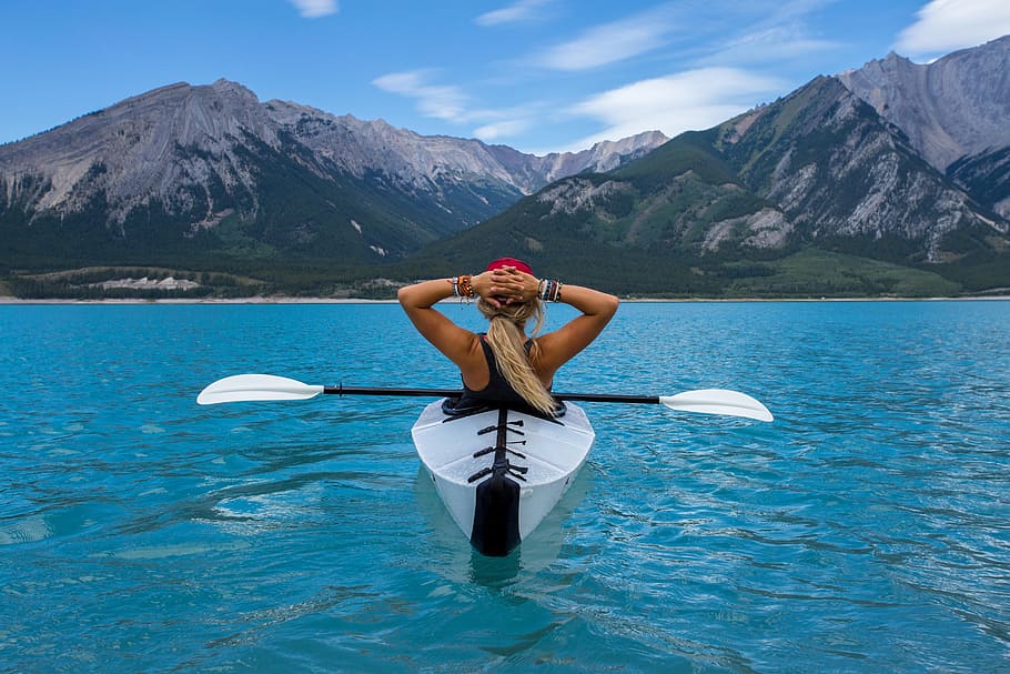 woman in white kayak with paddle on water mountain in distance at daytime, HD wallpaper
