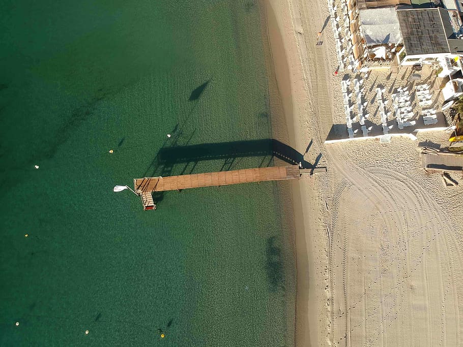 aerial photo of seashore and brown wooden dock towards sea during daytime, aerial photography of brown wooden dock HD wallpaper
