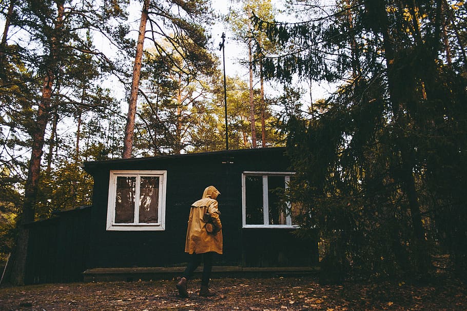 person wearing coat in front of house, man standing in front of house surrounded by trees HD wallpaper