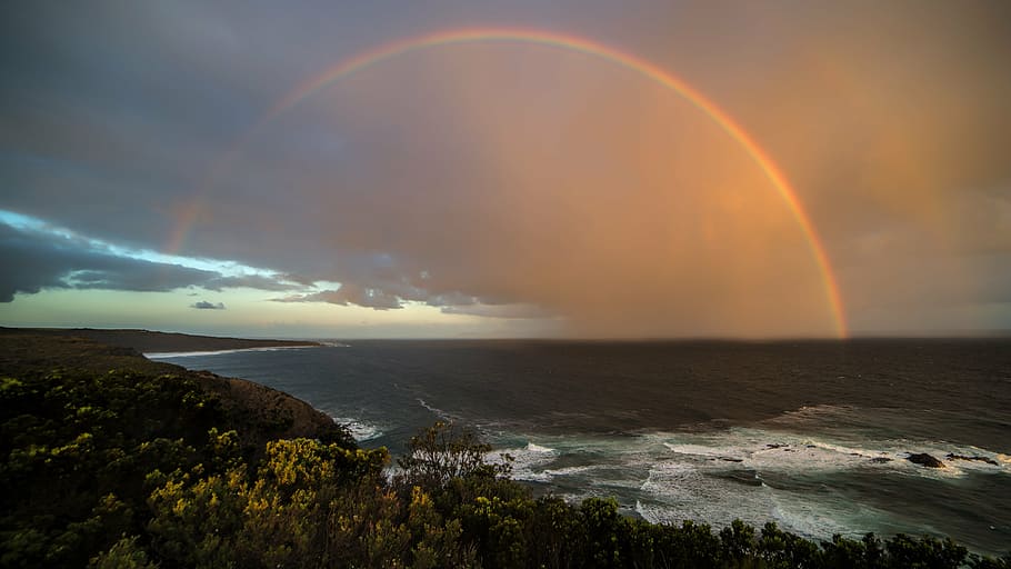 rainbow at distance over sea, coast, sunset, beach, sky, ocean