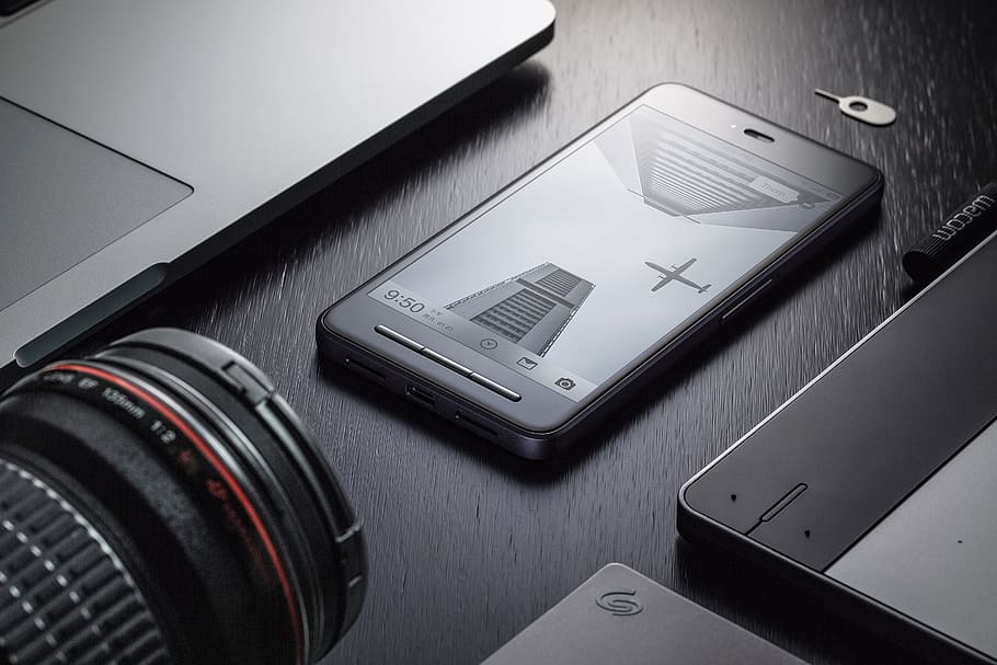 grayscale photography of black Android smartphone between laptop and camera lens HD wallpaper