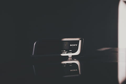 Sony digital alarm clock inside dark room, white and black Sony electronic device on top of black surface HD wallpaper