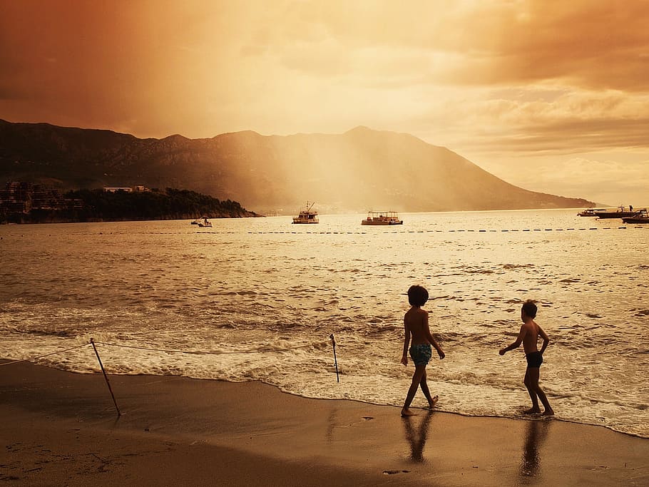two children standing on shore during golden hour, sunset, dusk HD wallpaper