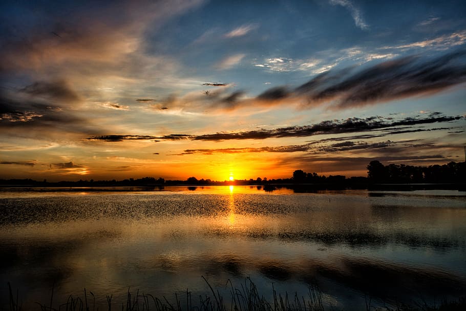 body of water and silhouette of mountain during golden hour HD wallpaper