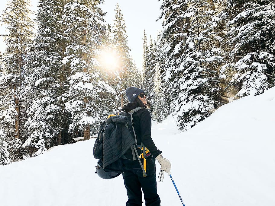 person standing near snow-covered forest, woman hiking a mountain during winter HD wallpaper