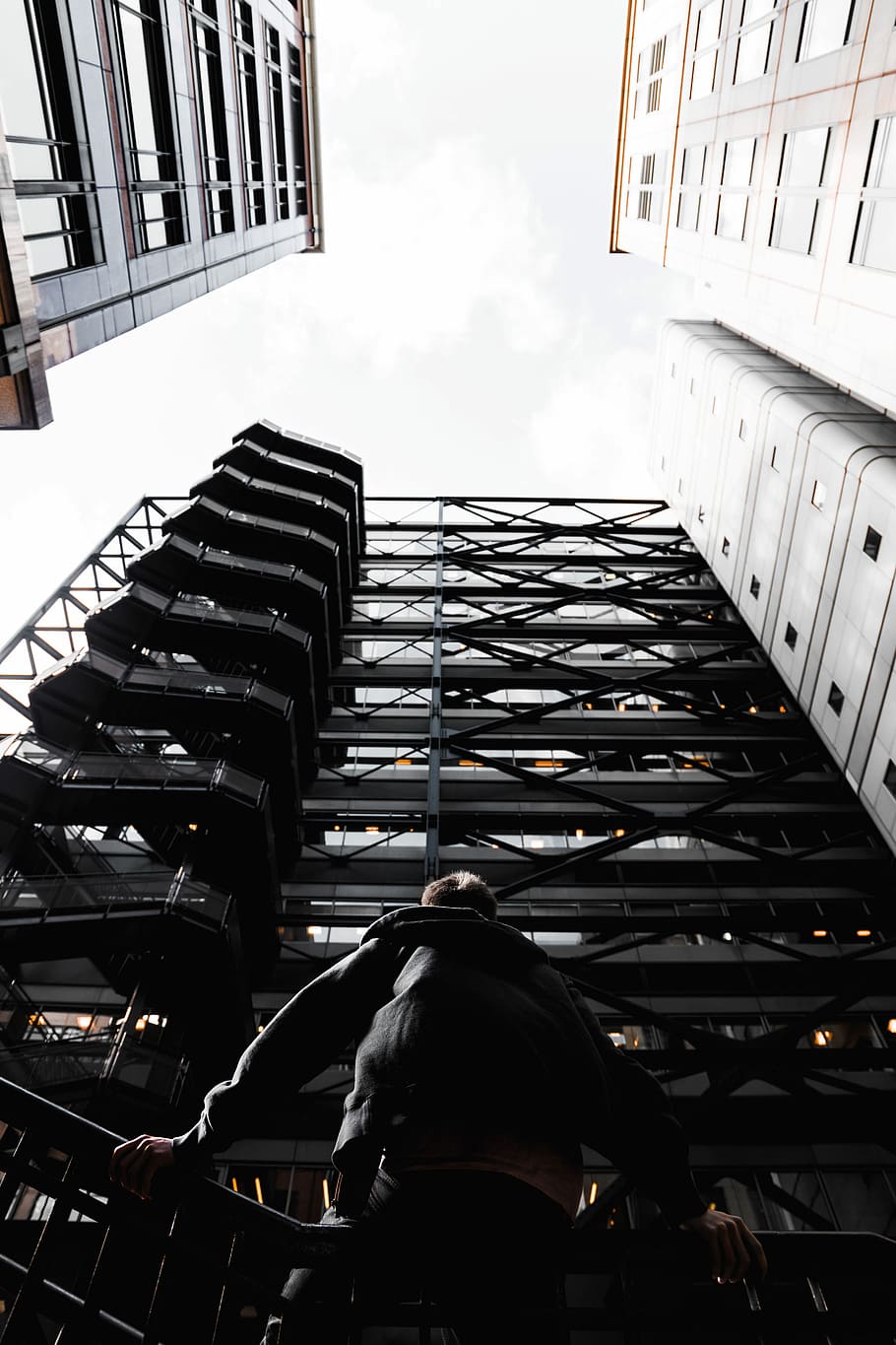 photo of man standing in front of black high-rise building, worm's eye-view photography of man standing in front of building HD wallpaper
