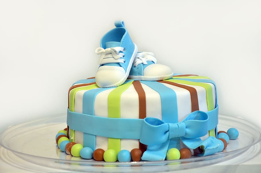 round striped cake decor with pair of blue shoes, baby shower