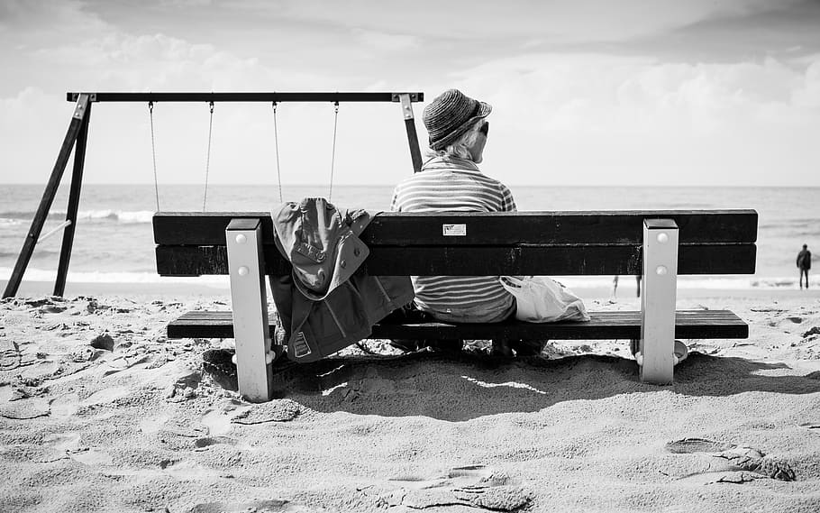 woman sitting on bench at beach, sand, people, swings, swing set