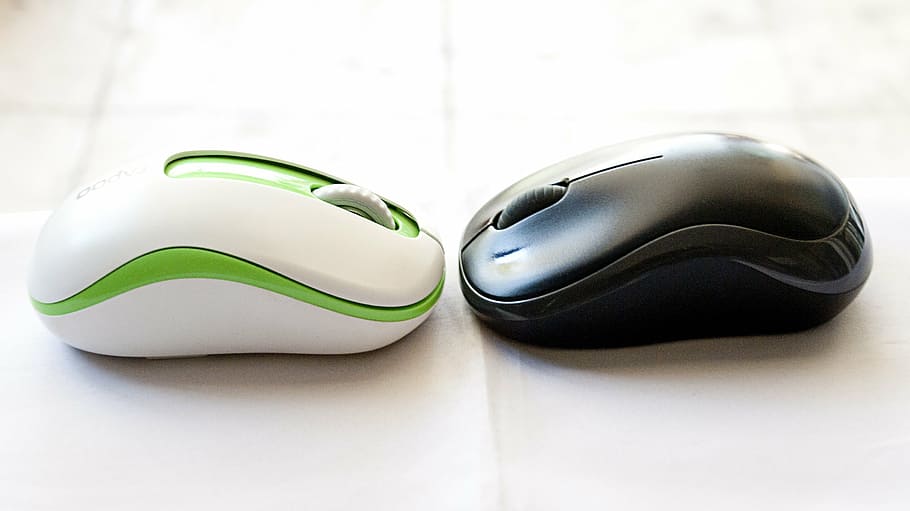 two black and white-and-green cordless computer mouse on white surface HD wallpaper