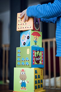 child building an four boxes, focus photo of toddler standing in front of assorted-color building blocks HD wallpaper